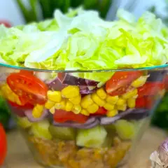 Warstwowa sałatka z kurczakiem, kukurydzą, pomidorami i sałatą lodową, doprawiona przyprawą gyros.
