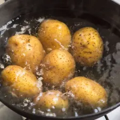 Ziemniaki gotujące się w garnku z wrzącą wodą.
