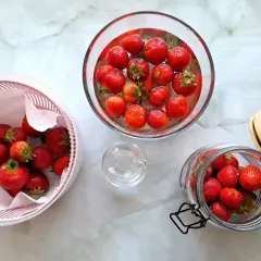 Truskawki w misce z wodą, suszarce i słoiku.