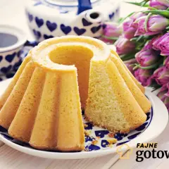 Puszysta babka na maślance, udekorowana filiżanką kawy i bukietem tulipanów. Idealna na wiosenne śniadanie.