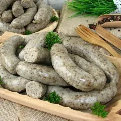 Pyszna kaszanka, idealna do przygotowania według tradycyjnego przepisu. Podana na drewnianej desce z ziołami i pieprzem.