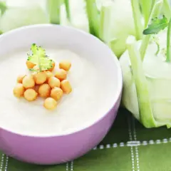 Kremowa zupa z kalarepy z grzankami w misce, obok świeże kalarepy.