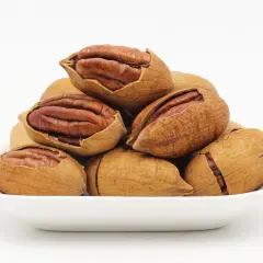 Stos pekany w łupinach w białej miseczce.