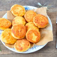 Talerz pełen złotych placków kukurydzianych (arepas) z widelcem obok.