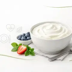 Gładki skyr naturalny w misce, obok jagody, truskawka i listki mięty. Zdrowy posiłek.