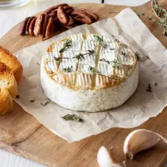 Pyszny, pieczony camembert z tymiankiem, podany z grzankami, orzechami pekan i czosnkiem. Idealny na przekąskę.