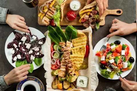 Pyszne dania kuchni greckiej: souvlaki, sałatka grecka, sałatka z buraków i pity. Smacznego!