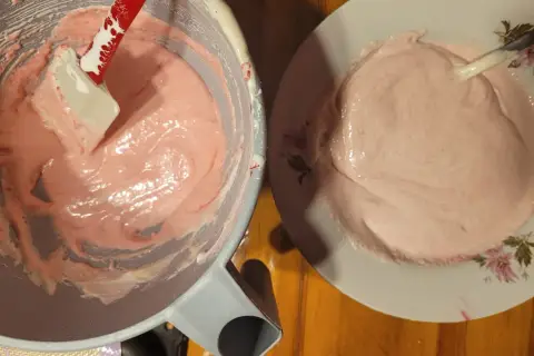 Różowa masa na makaroniki w misce i na talerzu. Ania gotuje, przygotowując ten słodki deser.