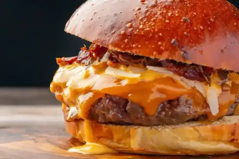Soczysty burger z rozpływającym się serem i chrupiącym boczkiem. Prawdziwa uczta dla podniebienia, choć wieśmac kcal może przyprawić o zawrót głowy.