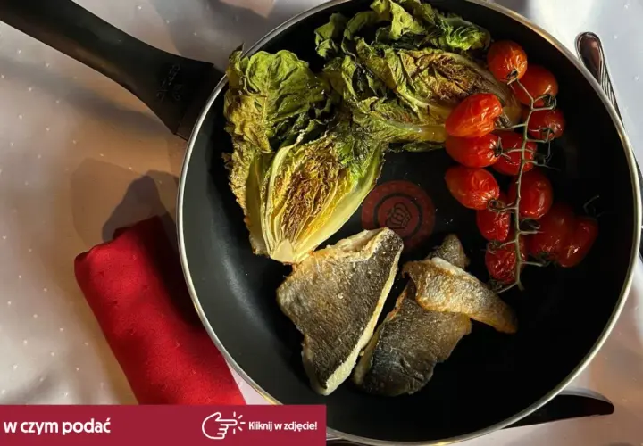 Smażona dorada z pomidorkami koktajlowymi i sałatą rzymską na patelni.