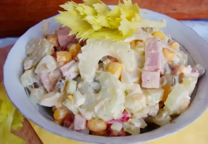 Sałatka z selerem naciowym, jajkiem, kukurydzą i szynką w sosie majonezowym.