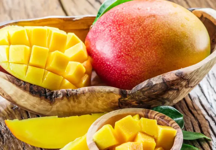 Soczyste mango w drewnianej misie, pokrojone w kostkę i w plasterkach. Odkryj jego niezwykłe mango właściwości.