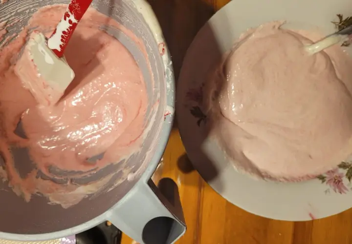 Różowa masa na makaroniki w misce i na talerzu. Ania gotuje, przygotowując ten słodki deser.
