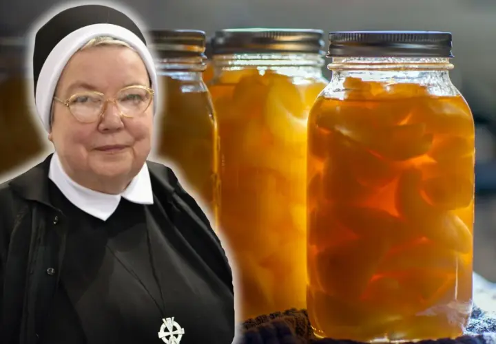 Zakonnica obok słoików z gruszkami w zalewie.