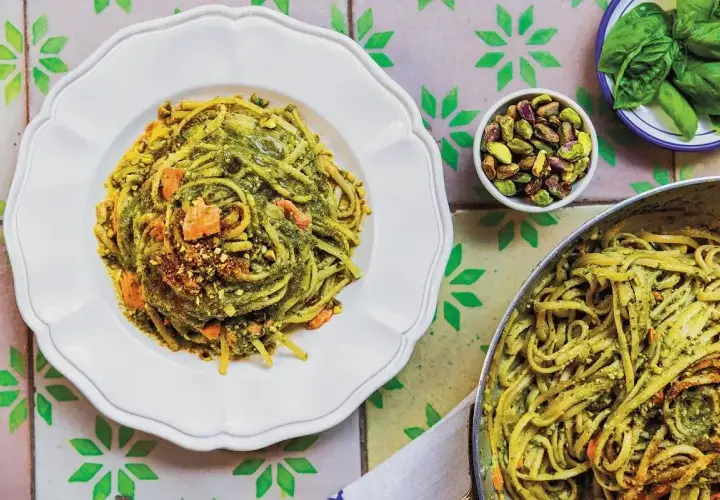 Linguine z pistacjami i zielonym pesto, idealne jaki makaron do pesto. Na talerzu i w garnku, z dodatkiem orzechów i bazylii.