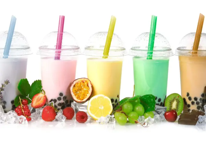 Pięć kolorowych bubble tea z owocami, lodem i słodyczami.