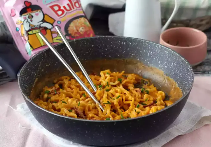 Pikantny buldak carbonara w kremowym sosie, gotowy do jedzenia.