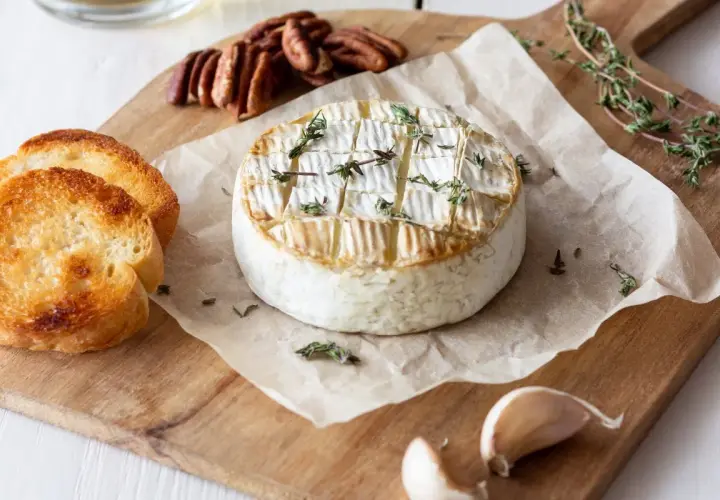 Pyszny, pieczony camembert z tymiankiem, podany z grzankami, orzechami pekan i czosnkiem. Idealny na przekąskę.