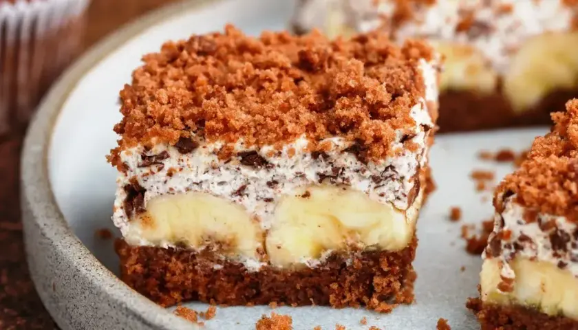 Proste ciasto bananowe z olejem i kakao, z warstwą kremu, bananów i posypką.