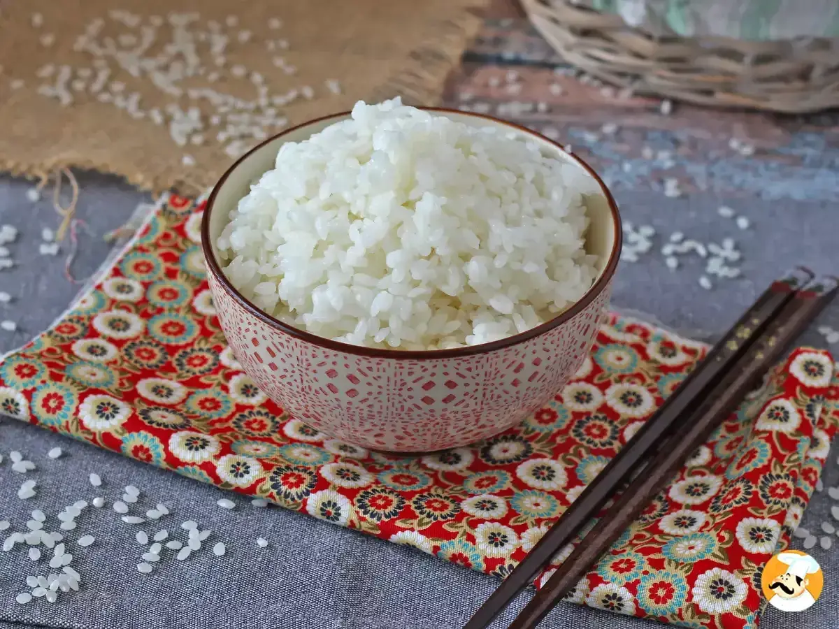 Miseczka kleistego ryżu do sushi na kolorowej serwetce z pałeczkami.