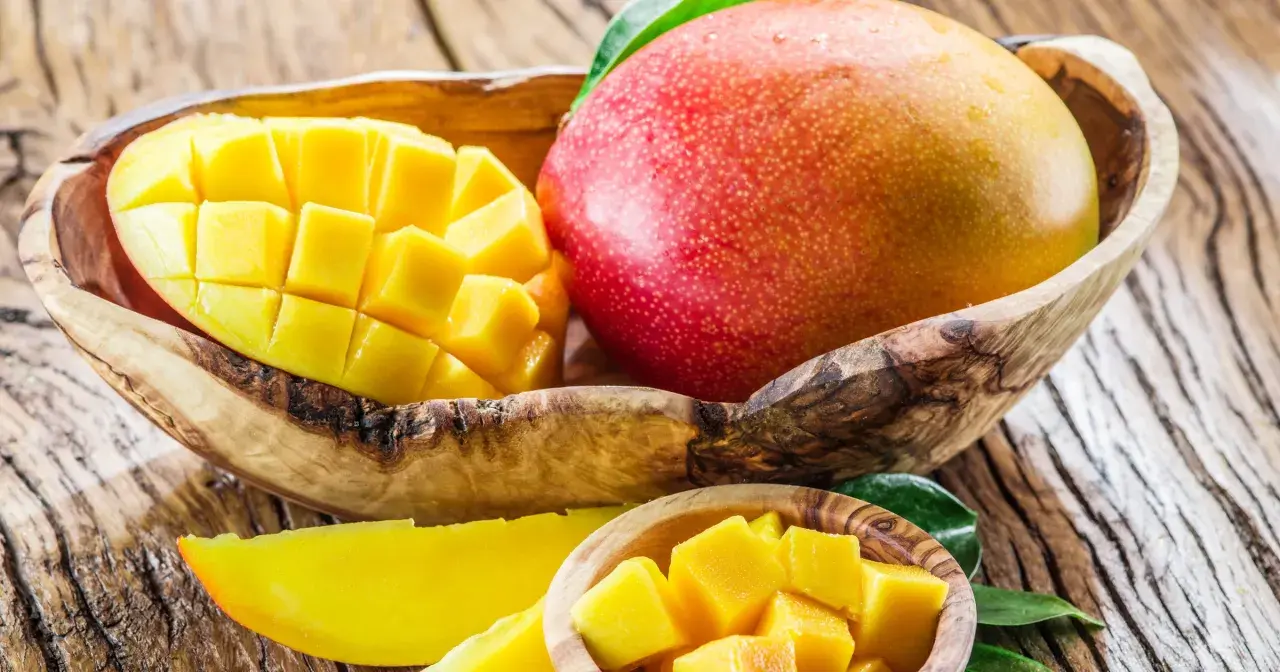 Soczyste mango w drewnianej misie, pokrojone w kostkę i w plasterkach. Odkryj jego niezwykłe mango właściwości.