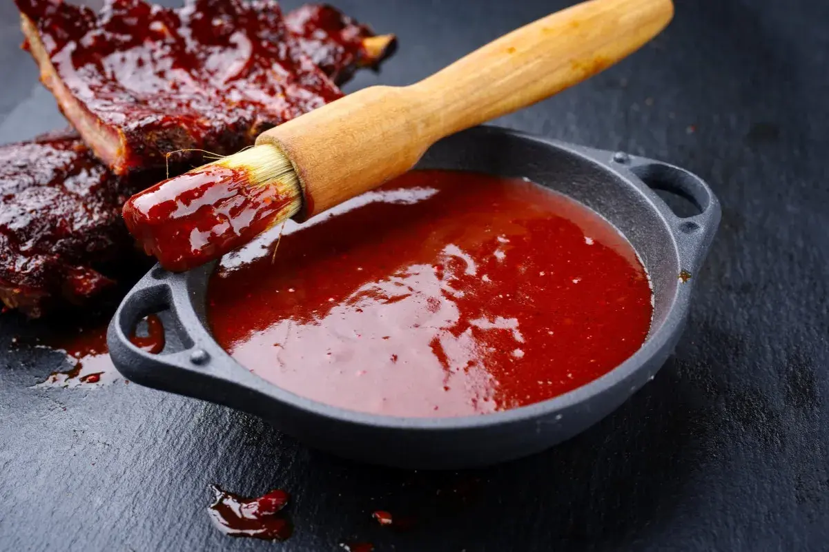 Pyszne żeberka w sosie barbecue, pędzelek zanurzony w sosie, gotowy do smarowania. Idealny sos barbecue przepis.