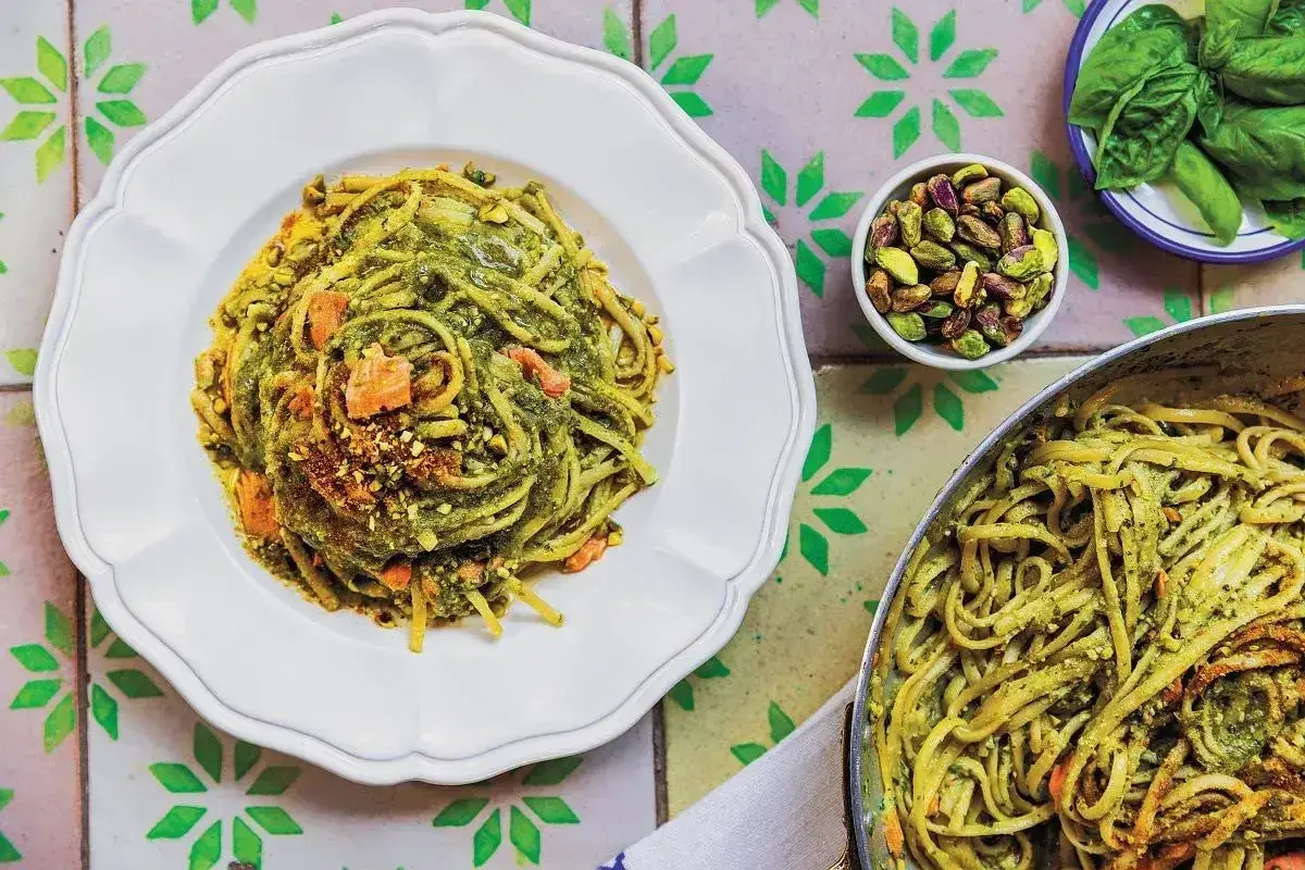 Linguine z pistacjami i zielonym pesto, idealne jaki makaron do pesto. Na talerzu i w garnku, z dodatkiem orzechów i bazylii.