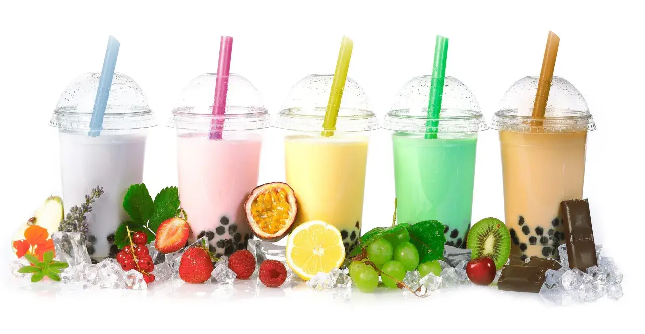 Pięć kolorowych bubble tea z owocami, lodem i słodyczami.