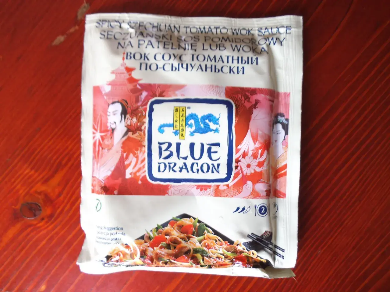 Sos seczuański Blue Dragon z pomidorami, idealny do dań z woka. Na opakowaniu smok i postacie z Azji.