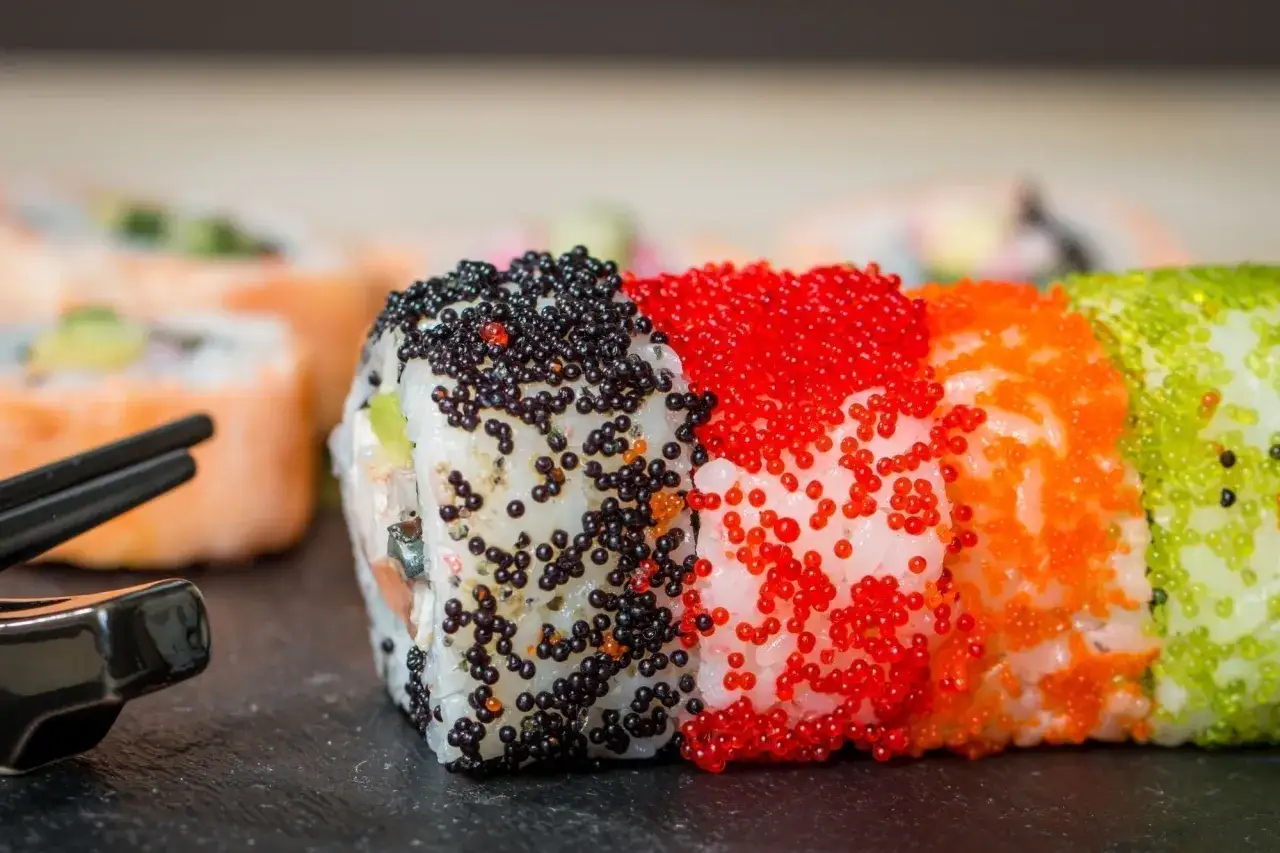 Rolki sushi z czarnym, czerwonym, pomarańczowym i zielonym tobiko. Wyglądają apetycznie!