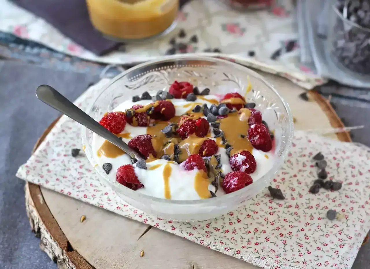 Pyszny deser z jogurtu typu skyr, malinami, polewą orzechową i czekoladą. Idealny na śniadanie lub przekąskę.