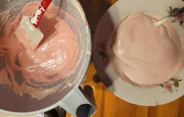 Różowa masa na makaroniki w misce i na talerzu. Ania gotuje, przygotowując ten słodki deser.